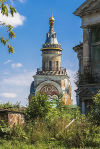 Low angle view of trees and building against sky