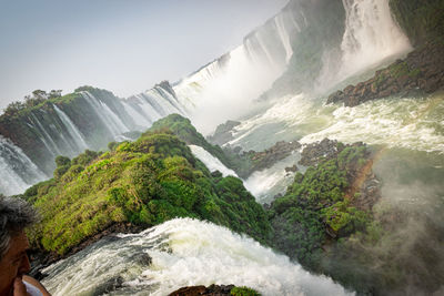 Scenic view of waterfall against sky