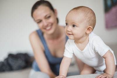 Portrait of baby girl with mother on couch