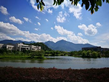 Houses by lake against sky