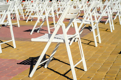 Folding chairs are arranged on recreation area. empty folding wooden chairs in a public square