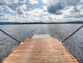 View over ferry metal boat against the wavy lake water and a blue sky