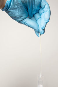 Midsection of person holding umbrella against white background