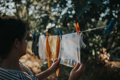 Midsection of man holding woman hanging on clothesline