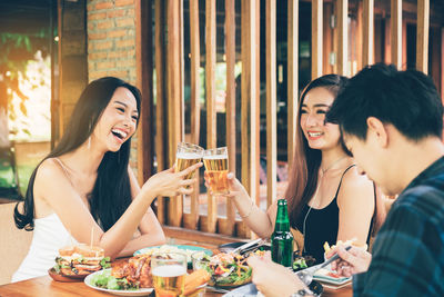 Young woman drinking glass on table at restaurant