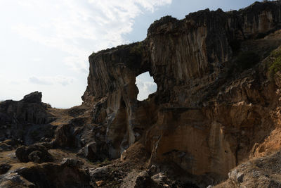 Low angle view of rock formations against sky