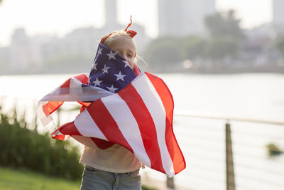 Rear view of woman holding american flag