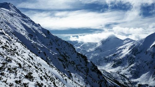 Scenic view of snow covered mountains against sky