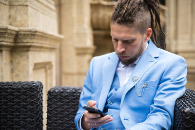 Man wearing blue suit using smart phone