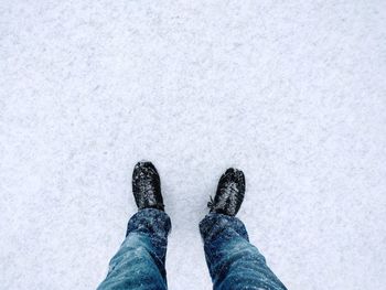 Low section of man standing on snow