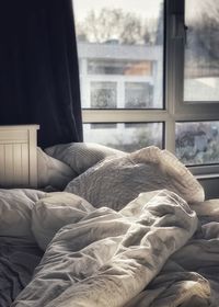 Midsection of person relaxing on bed at home