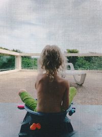 Rear view of woman standing by swimming pool