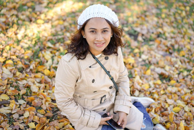 Portrait of a smiling woman with autumn leaves