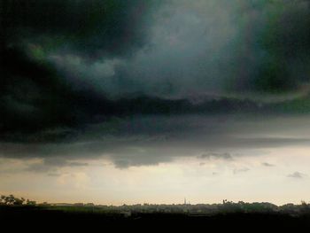 Scenic view of dramatic sky over silhouette landscape