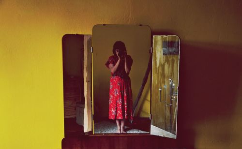 Rear view of woman standing against wall