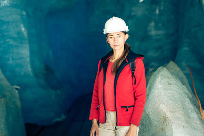 Portrait of young woman standing against water