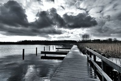 View of pier on sea against cloudy sky