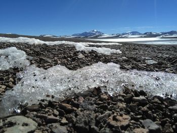 Surface level of snow covered landscape against sky