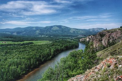 Scenic view of river amidst green landscape against sky