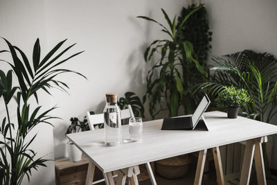 Digital tablet and water bottle on table at home office