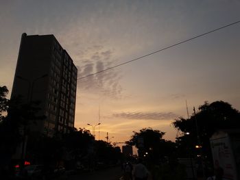 Low angle view of silhouette buildings against sky at sunset