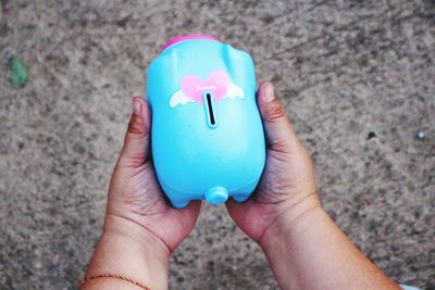 Close-up of hand holding piggy bank