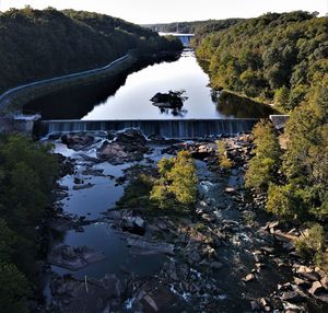 High angle view of river amidst trees against sky