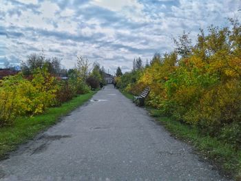 Road amidst trees against sky during autumn