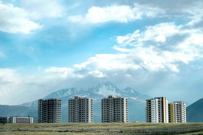 Buildings in city against cloudy sky