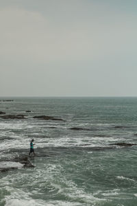 Man surfing in sea against sky