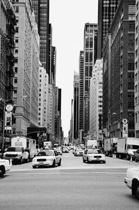 Traffic on road by buildings in city