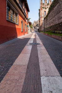Empty road amidst buildings in city