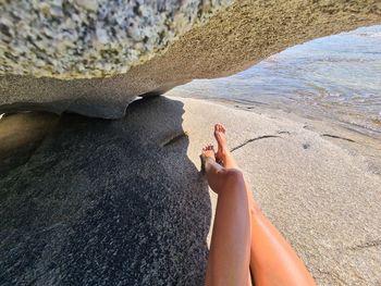 Low section of woman relaxing on beach