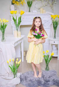 Portrait of young woman standing against wall