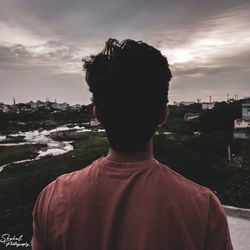 Rear view of man looking at sea against sky