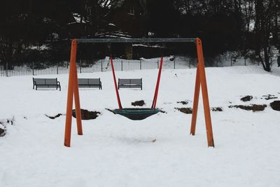 Snow covered swing in field