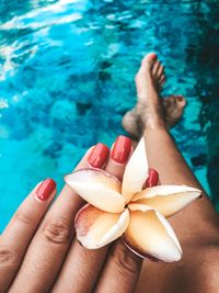 Close-up of woman holding hands in swimming pool