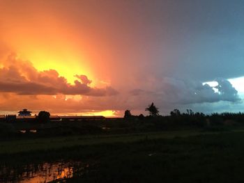 Scenic view of silhouette field against sky during sunset