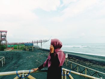 Rear view of woman looking at sea against sky