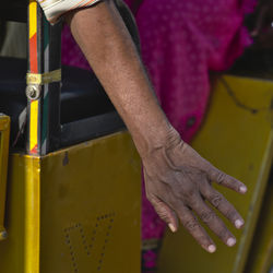 Midsection of man holding yellow while standing on floor