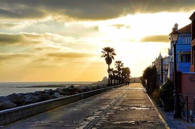 Scenic view of sea against cloudy sky at sunset