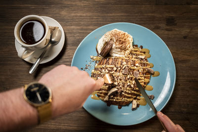 Cropped image of hand holding coffee cup