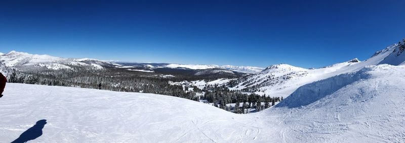 Scenic view of snowcapped mountains against clear blue sky