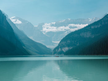 Scenic view of lake and snowcapped mountains against clear sky