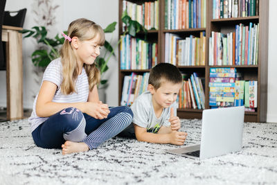 Children watch lessons through a laptop and make online calls.social media and the use of technology