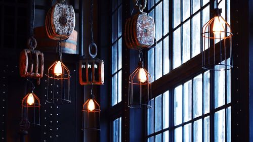 Low angle view of illuminated lamp hanging on wall