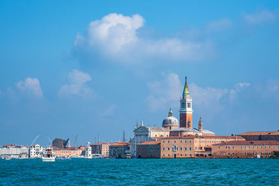 View of buildings by sea against sky