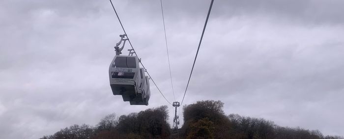 Low angle view of overhead cable cars against sky