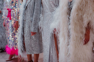 Silhouettes of fashion models on backstage dressed in a long haute couture boudoir dresses outfits. 