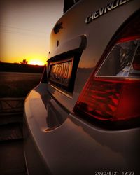 Close-up of car against sky during sunset